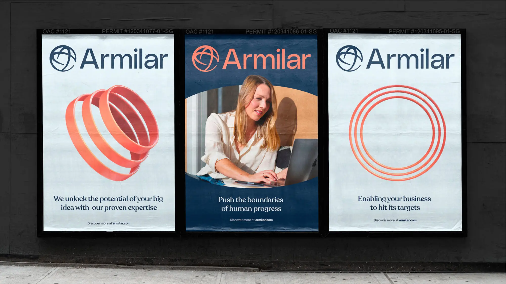 A street with three graphic Armilar posters pasted on the wall. The middle poster features a woman working and the title “Push the boundaries of human progress”.