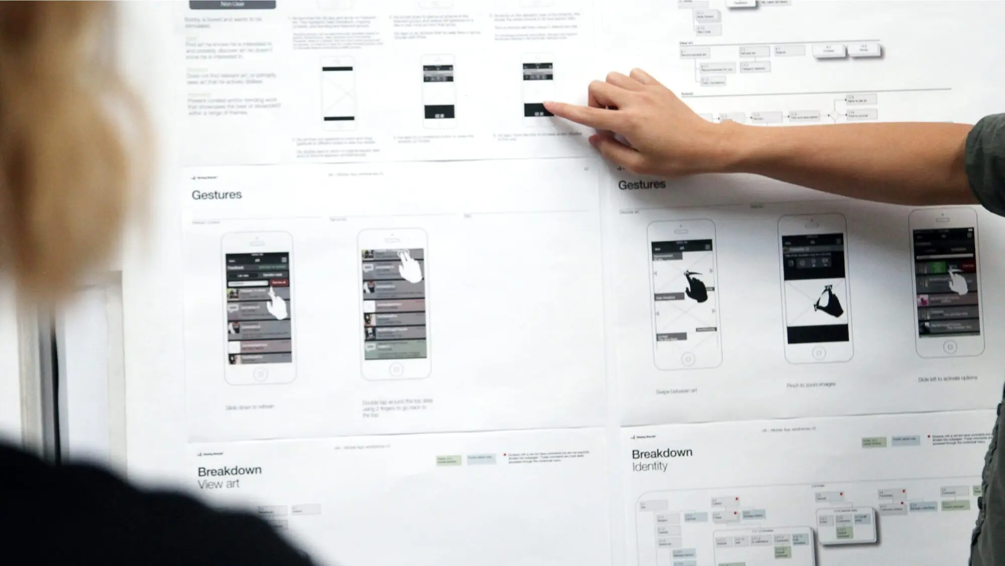 A designer points at a printout of the DeviantArt brand work.