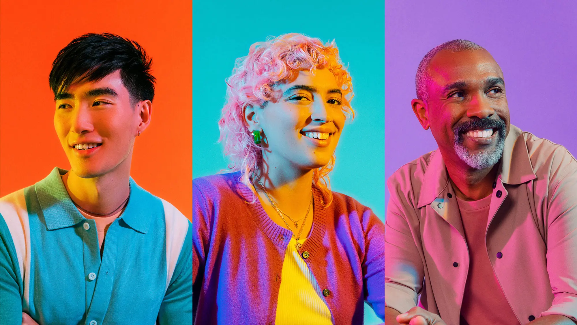 A group of people smiling in front of a colourful background, suggesting a diverse workforce.