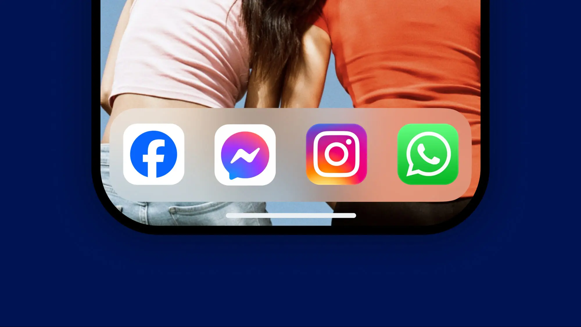 The bottom half of a phone screen with four app icons on screen of Facebook, Messenger, Instagram, and WhatsApp. The wallpaper shows two people from the back leaning on each other.